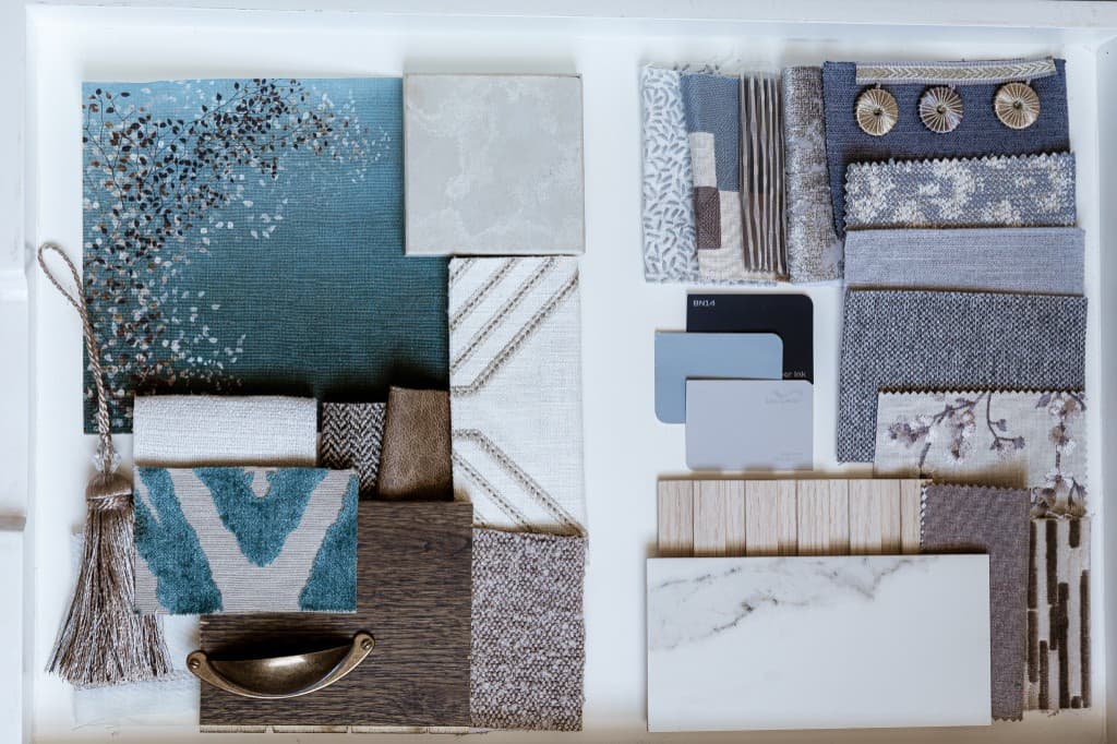 Curated tray of sage, cream, and grey textiles with wood and paint chips.