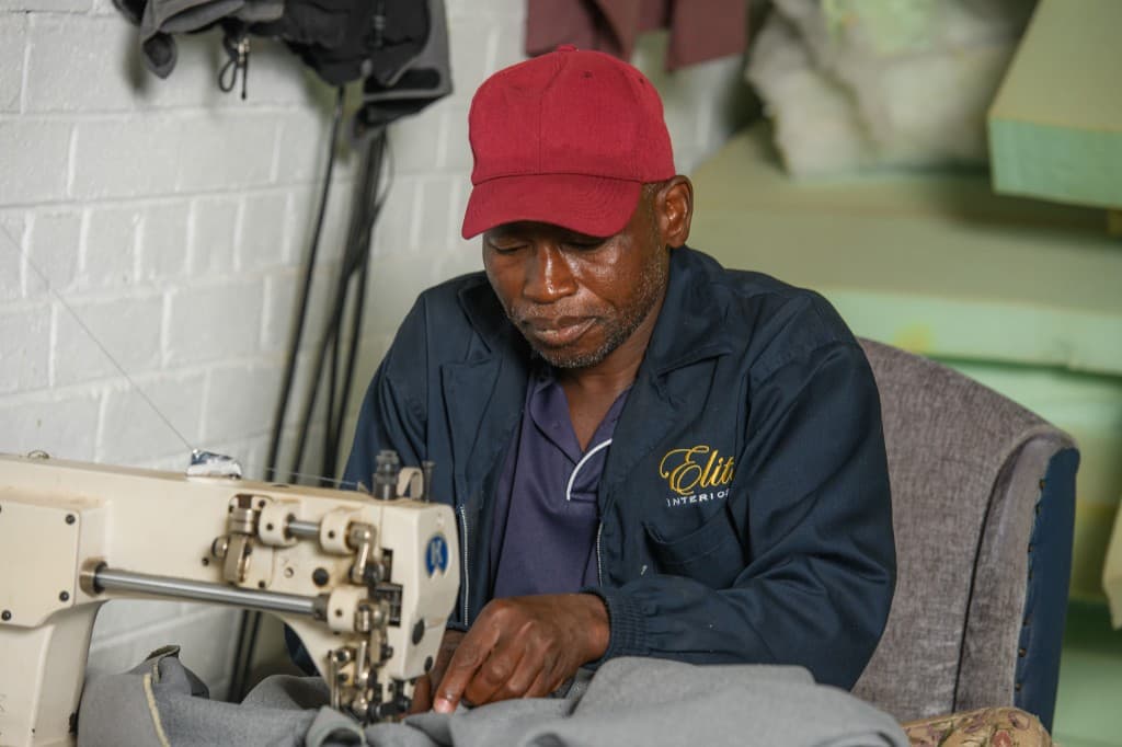 Industrial sewing — heavy textiles guided through the machine in the workroom.