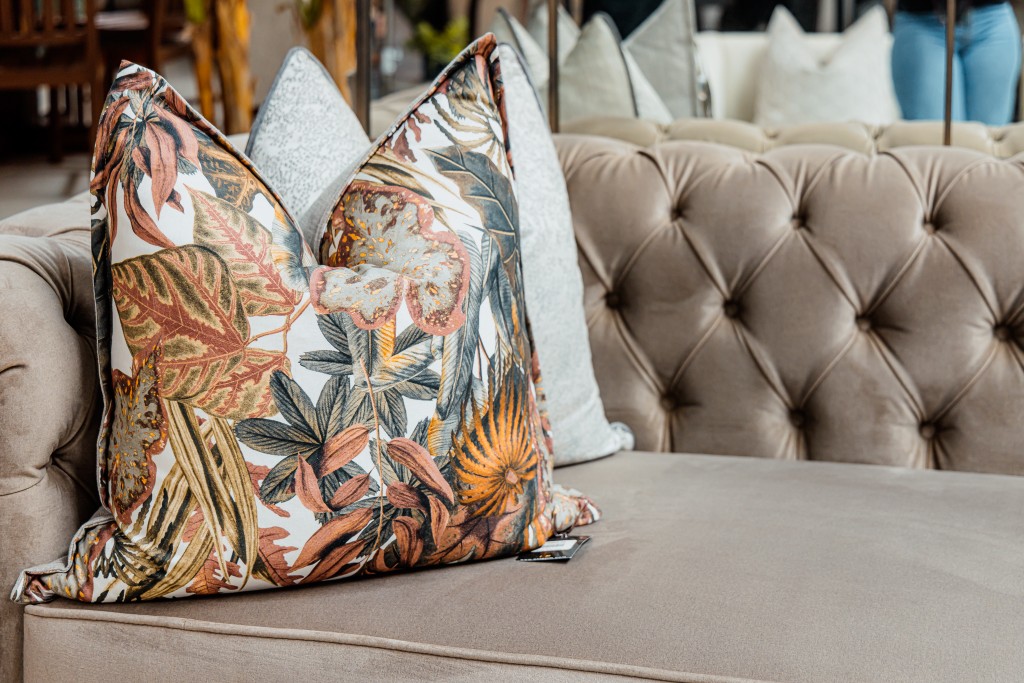 Botanical print cushion on a tufted chesterfield sofa