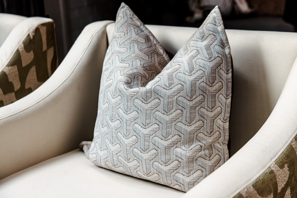 Geometric patterned cushion on a cream sculptural armchair